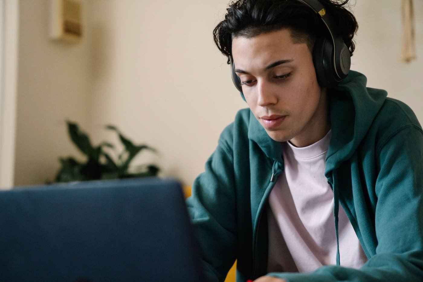 Kulaklık takıp laptopla sınava çalışan bir kişi