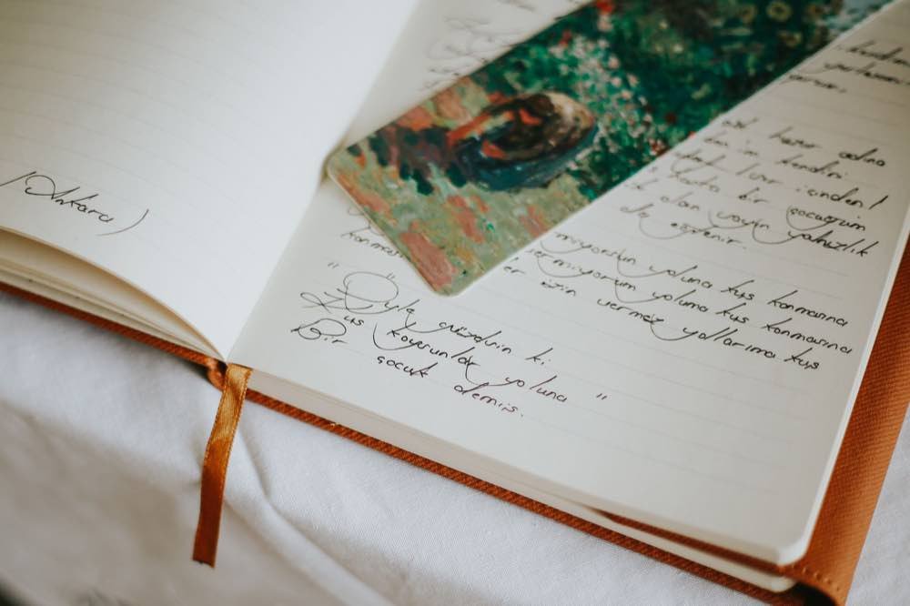 Küçük bir tablo ile birlikte el yazısı notlar içeren açık bir defter